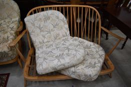 An Ercol cottage style settee, slight splitting to one arm