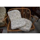 An Ercol cottage style settee, slight splitting to one arm