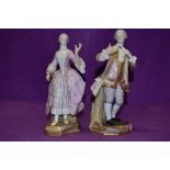 A pair of Meissen figurines of gentleman and companion, the gent is wearing a pink frock coat with