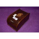 A vintage wooden roll top cigarette box with kinetic internal movement, having ship design to top.