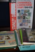 A selection of stamps and stamp collecting reference books.