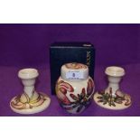 A pair of candlesticks and a ginger jar having cream ground with pink magnolia like design,