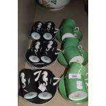 An assortment of coffee cups and saucers including green by Bishop and matte black with sea horse