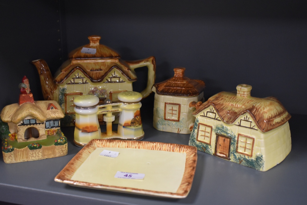 A collection of hand painted country cottage ceramics including tea pot, cheese dome, lidded sugar