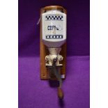 A vintage wall mounted ceramic crank handed coffee grinder with removable glass container to collect