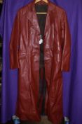 A vintage full length red leather coat with belt.around a small to medium size.