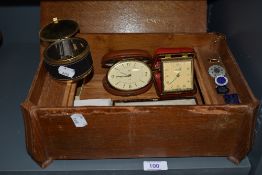 A vintage wooden box containing an assortment of items,cufflinks, travel clocks, compacts, badges