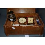A vintage wooden box containing an assortment of items,cufflinks, travel clocks, compacts, badges