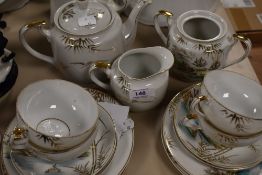 A part oriental lithopane tea set having hand tinted and gilt detailing, around fifteen items.