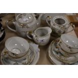 A part oriental lithopane tea set having hand tinted and gilt detailing, around fifteen items.