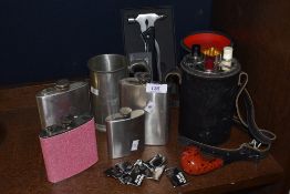 A collection of hip flasks and compartmental hip flask case with three flasks,pipe, tankard and