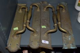 Four vintage brass door handles with integral finger plates.