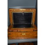 A late Victorian golden oak veneered mahogany writing slope, having brass corner protectors and