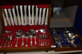 Two canteens containing a selection of insignia plate cutlery