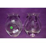 A pair of glass vases having etched designs one with butterfly design the other tree and landscape