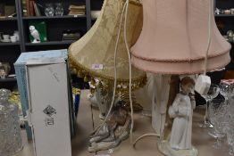 Two table lamps in a Lladro style, one with girl holding pillow and clock and the other a sleeping