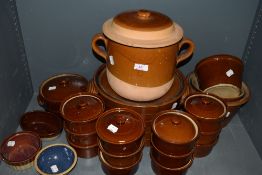 A large collection of vintage earthen ware dishes, lidded pots and graded basins.