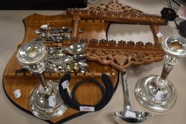 An assortment of plated ware and collectable spoons with two display racks.