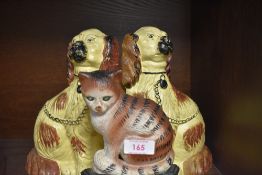 Three cast iron door stops, two in the form of a pair of mantel dogs and one,a cat.