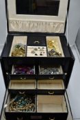 A black travel jewellery box containing a selection of costume jewellery including wrist watches,