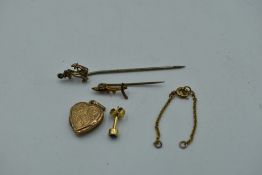 A small selection of 9ct gold and broken yellow metal including an anchor pin, heart shaped