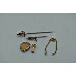 A small selection of 9ct gold and broken yellow metal including an anchor pin, heart shaped