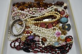 A selection of costume jewellery including brooches and strings of pearls and beads etc