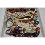 A selection of costume jewellery including brooches and strings of pearls and beads etc