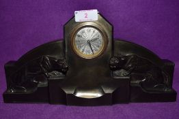 An art deco bronzed mantel clock having silver dial of stepped design with wild cats / Jaguars to