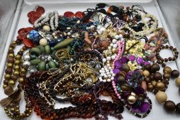 A large selection of costume jewellery necklaces including metal, wood, simulated pearls, cord etc