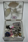 A decorative box containing a selection of stud and clip fashion earrings etc