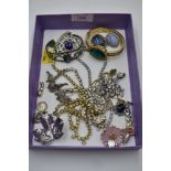 A selection of costume jewellery including diamante, bangle watch, brooches, religious charm etc