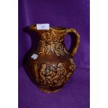 An earthen ware salt glazed jug having impressed scene