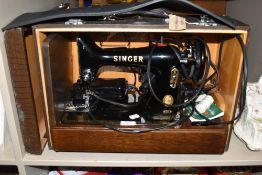 A vintage Singer sewing machine in wooden case, plate reads EJ779214.