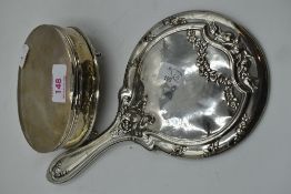 An HM silver dressing table hand mirror having moulded bow detail and an HM silver dressing table