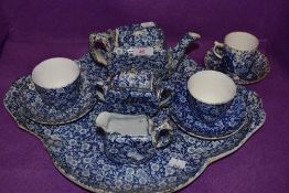 An antique chintz breakfast tray and tea set unmarked and un named most pieces having damage