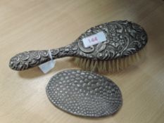 An HM silver dressing table brush having moulded decoration and an HM silver clothes brush cover