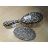 An HM silver dressing table brush having moulded decoration and an HM silver clothes brush cover