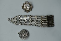 A HM silver seven bar gate bracelet of traditional form and two white metal brooches