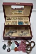 A small jewellery box containing vintage costume jewellery necklaces, polished mineral pendant,