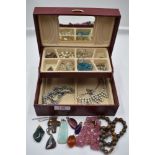 A small jewellery box containing vintage costume jewellery necklaces, polished mineral pendant,