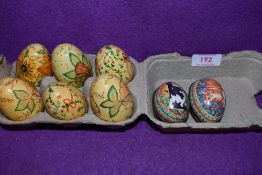 Six painted wooden eggs each with different designs, also included are two tins.