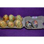 Six painted wooden eggs each with different designs, also included are two tins.