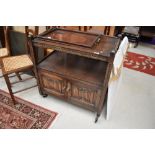 An oak tea trolley having under cupboard