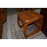 A vintage teak Nathan nest of three tables, of stylised form