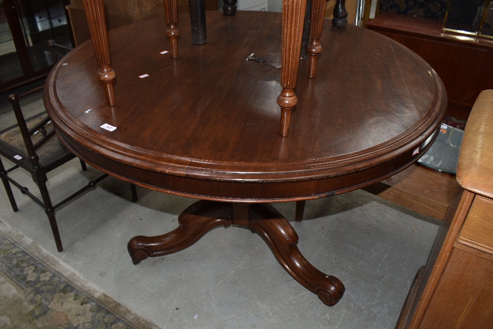 A Victorian mahogany snap top dining table on turned column and triple splay legs