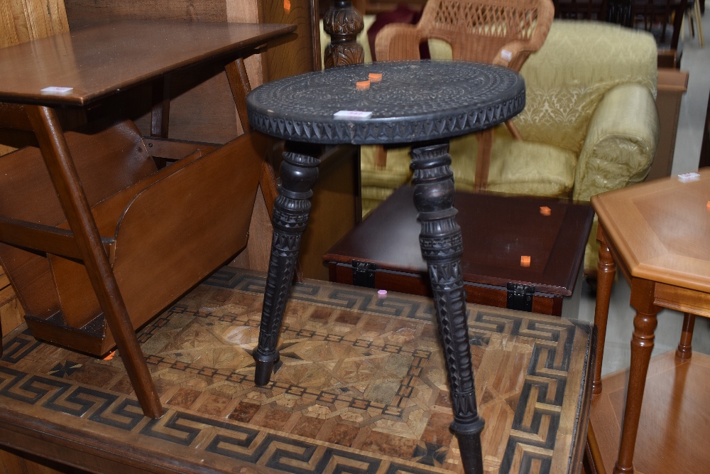 A traditional carved tri legged stool, with Islamic influences