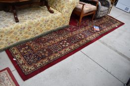 A large carpet square having vibrant green and red ground approx 320cm x 280cm good condition one