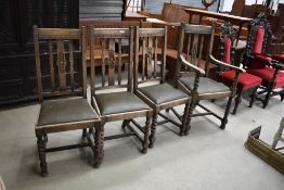 Four oak dining chairs having carved backs and leather seats