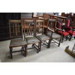 Four oak dining chairs having carved backs and leather seats